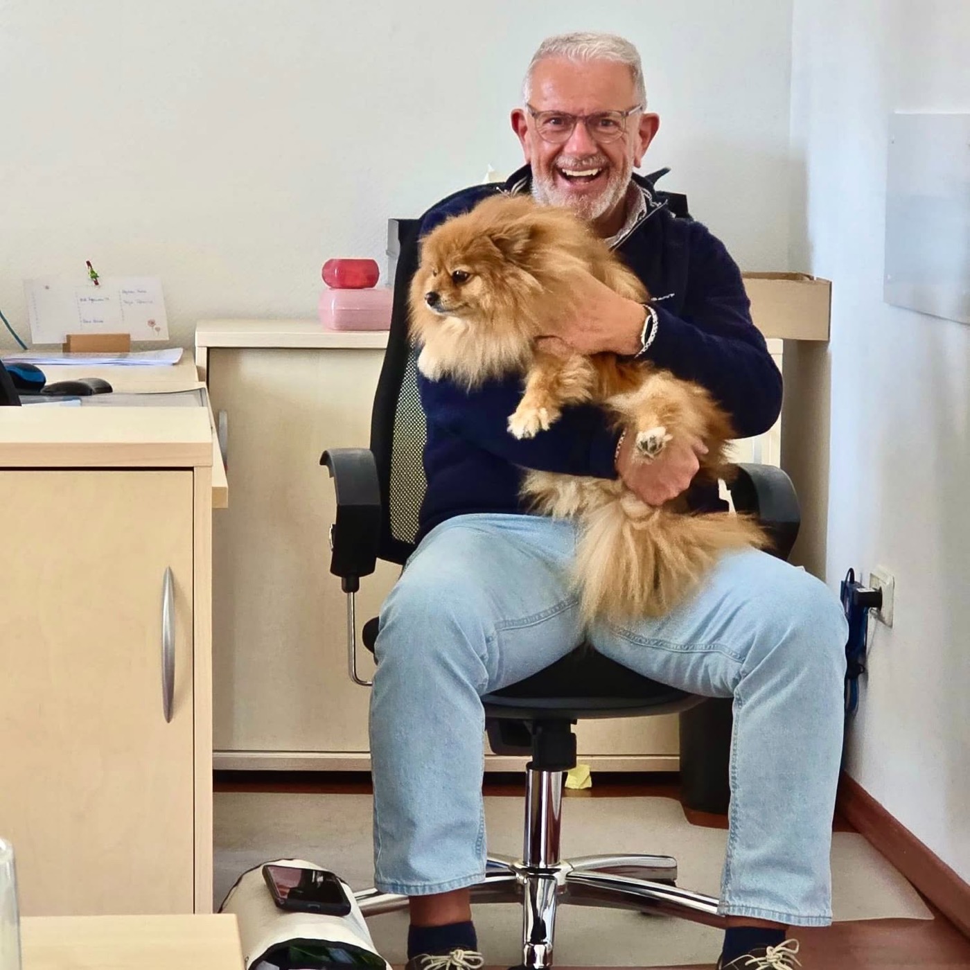 Herbert Hildebrand, Geschäftsführer der Sozialstation, mit dem Bürohund auf dem Schoß