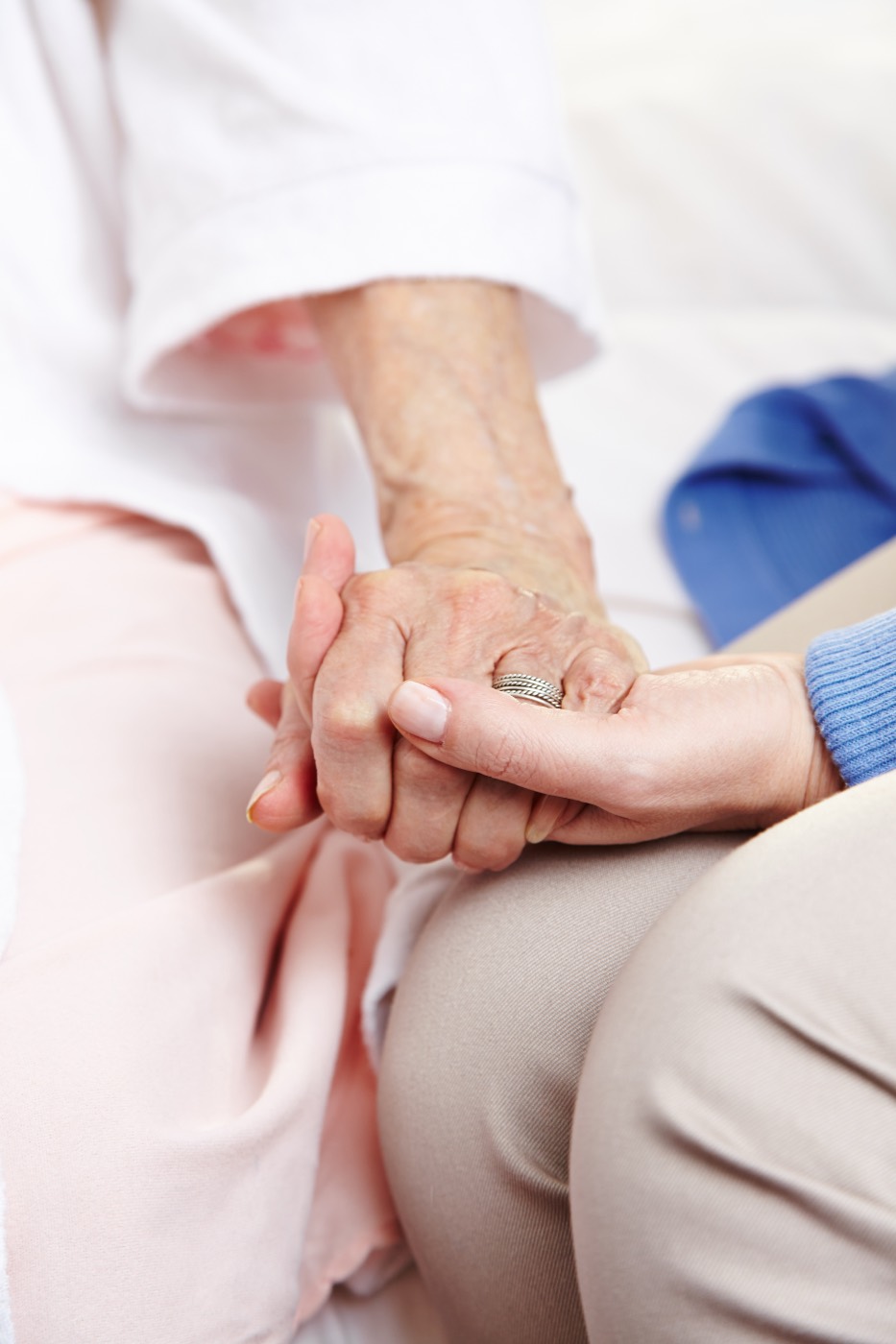 Palliativpflege: Eine Pflegekraft hält die Hand einer Seniorin